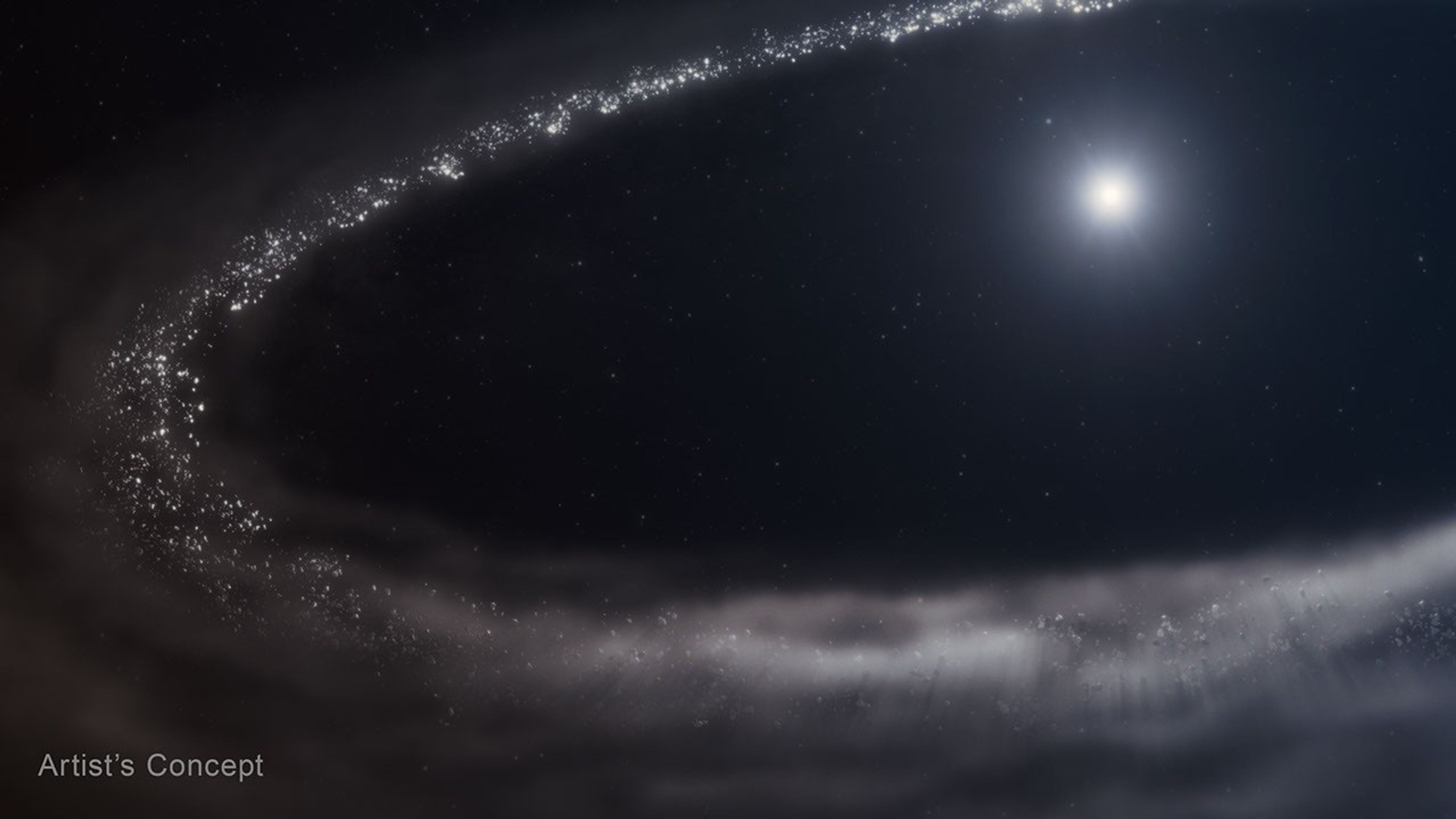 An illustration of Sun-like star HD 181327 and its surrounding debris disk. The star is at top right. It is surrounded by a far larger debris disk that forms an incomplete ellpitical path and is cut off at right. There’s a huge cavity between the star and the disk. The debris disk is shown in shades of light gray. Toward the top and left, there are finer, more discrete points in a range of sizes. The disk appears hazier and smokier at the bottom. The star is bright white at center, with a hazy blue region around it. The background of space is black. The label Artist's Concept appears at lower left.